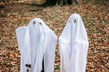 Two children in homemade ghost costumes made of sheets