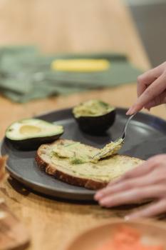 A person making avocado toast.